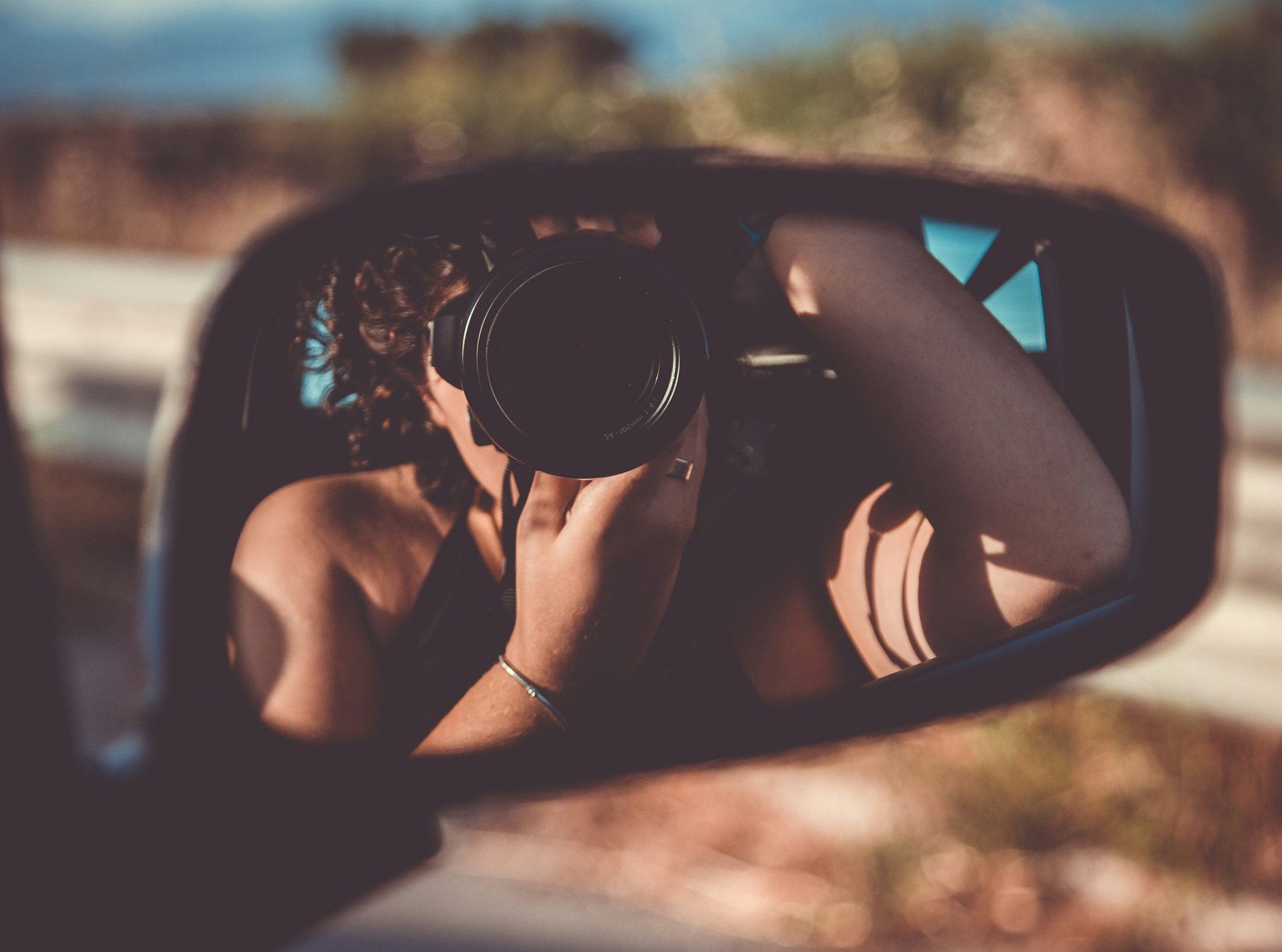 girl-taking-photo-in-car-wing-mirror