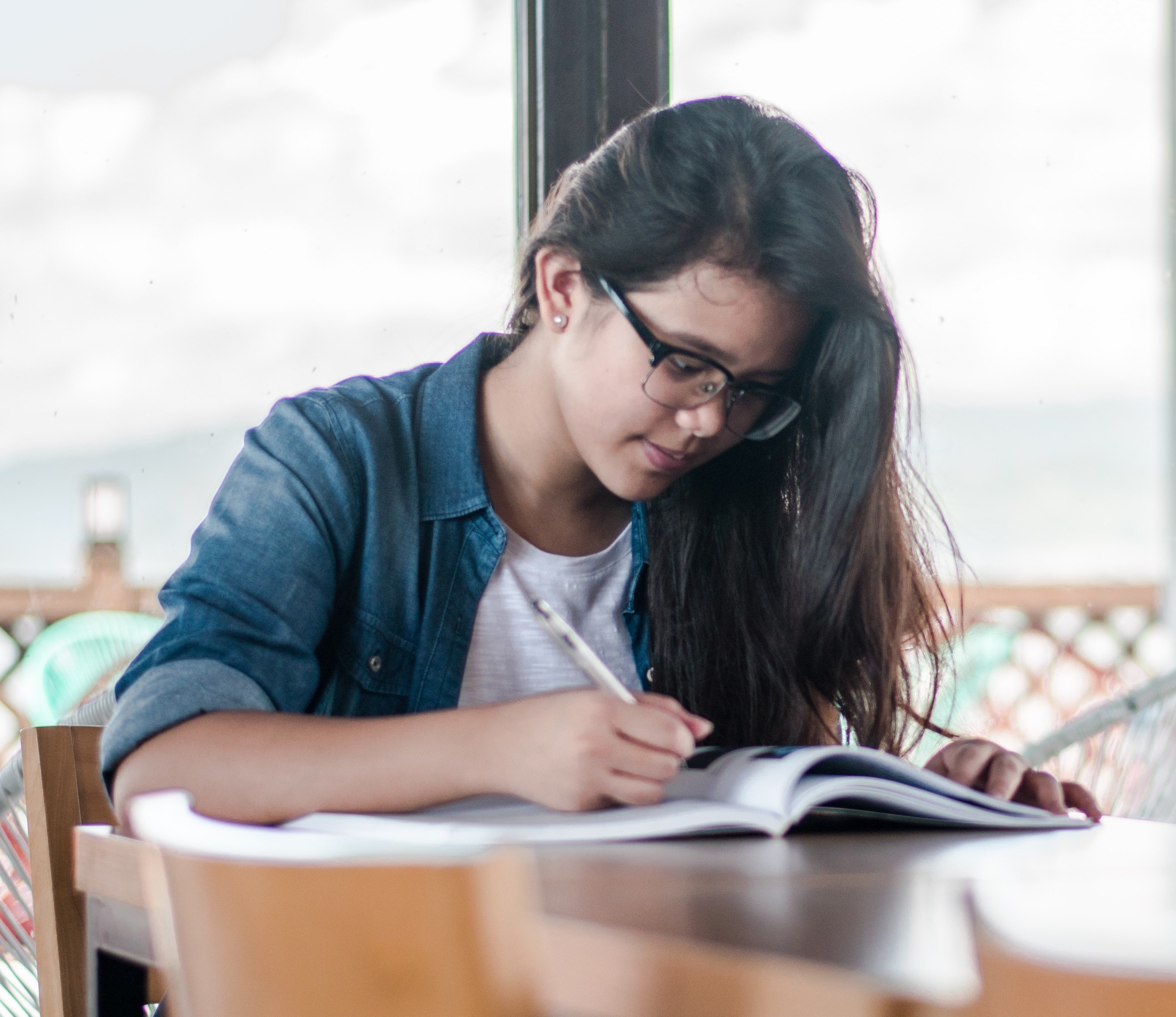 girl-writing-table-glasses-window